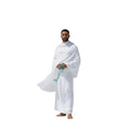 Man in white Ihram clothes holding a string on a plain background