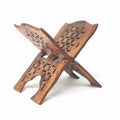 A wooden Quran folding stand or holder with a design, likely handcrafted.